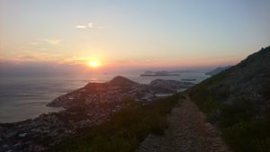 The sun setting as seen from Mount Srd with island in the background