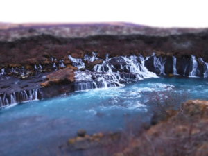 A photo showing the small rivulets falling over Icelandic volcanic rock to join the main river at Hraunfossar waterfalls