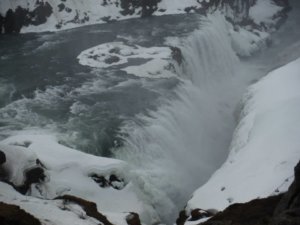 The powerful Gullfoss waterfall surrounded by snow on a wintry afternoon