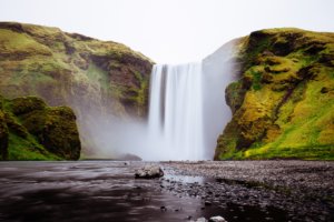 The mighty waterfall of Skogafoss with its 60m drop surrounded by green hills to either side. Simply spectacular