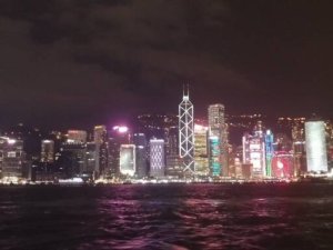 Iconic skyline at night of Hong Kong harbour at night taken from the Star Ferry