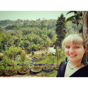 A picture of me in front of the sea of green palm trees at the Bali Swing visited during four fun days in Ubud