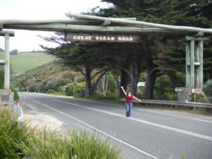 Standing in front of the Great Ocean Road sign in Australia